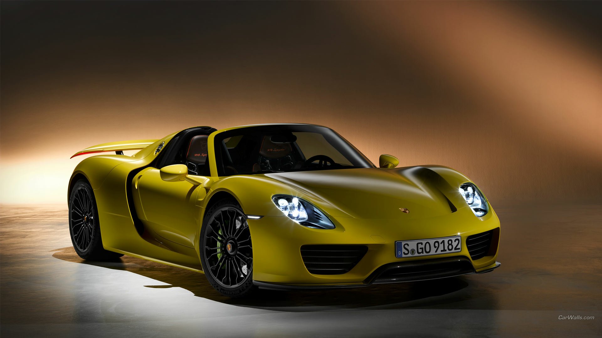 HD PC desktop wallpaper of a lime-green Porsche 918 Spyder sports vehicle, shown front-left with headlights on against a smooth dark gradient background.