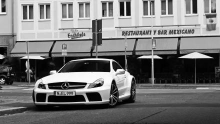 Black and white 4K Ultra HD wallpaper featuring a Mercedes-Benz SL65 parked on a city street in front of a Mexican restaurant.