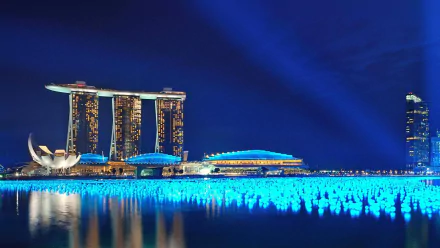 HD PC desktop wallpaper background: Marina Bay Sands in Singapore at night, man-made illuminated light installation reflecting across calm Marina Bay waters.