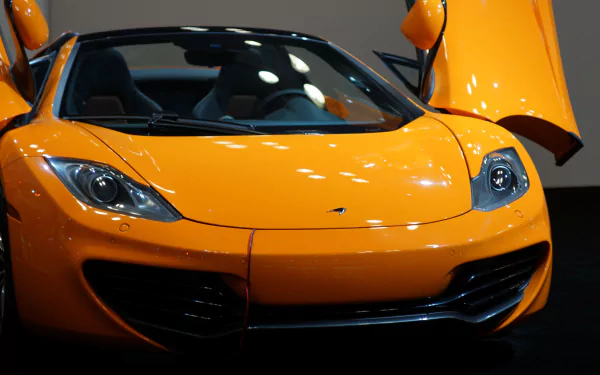 A vibrant orange McLaren sports car with butterfly doors open, captured in stunning 4K Ultra HD for a dynamic PC desktop wallpaper.