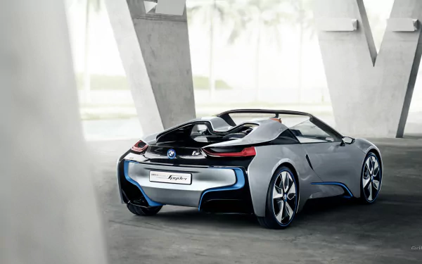Vehicle: rear three-quarter view of a silver BMW i8 Concept Spyder in a modern concrete pavilion, HD PC desktop wallpaper background.