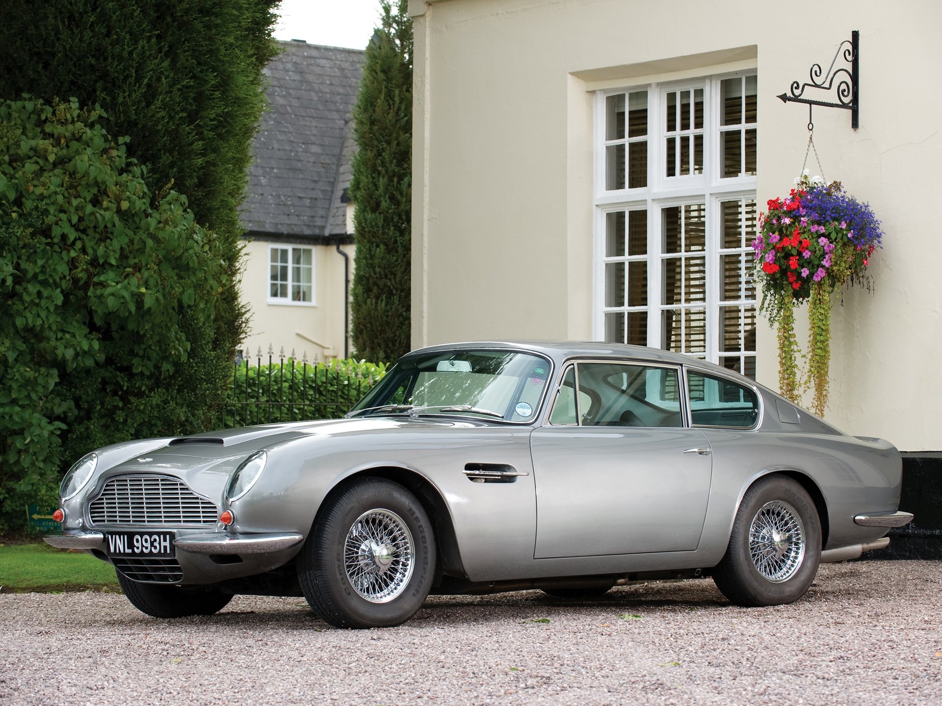 Aston Martin DB6 parked in front of a house, featured as a high-definition PC desktop wallpaper and background.