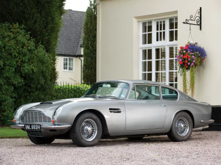 Aston Martin DB6 parked in front of a house, featured as a high-definition PC desktop wallpaper and background.
