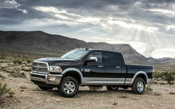 HD desktop wallpaper featuring a black Dodge Ram Heavy Duty truck parked in a rugged desert landscape under a dramatic cloudy sky.