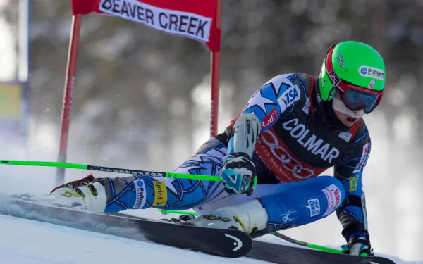 HD PC desktop wallpaper of slalom skiing — Sports action of a racer carving a low, high-speed turn at Beaver Creek, snow spraying.
