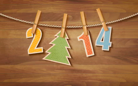 Colorful cutouts of the numbers 2, 0, 1, and 4 along with a green Christmas tree are clipped to a string against a wooden background, celebrating New Year 2014.