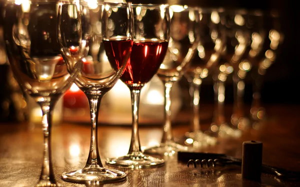 Close-up view of wine glasses filled with red and white wine on a wooden surface, captured in stunning 4K Ultra HD quality as a PC desktop wallpaper background.