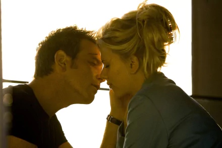 Film still from The Island: two actors in an intimate, backlit close-up with faces inches apart, warm tones — 2K Quad HD PC desktop wallpaper.