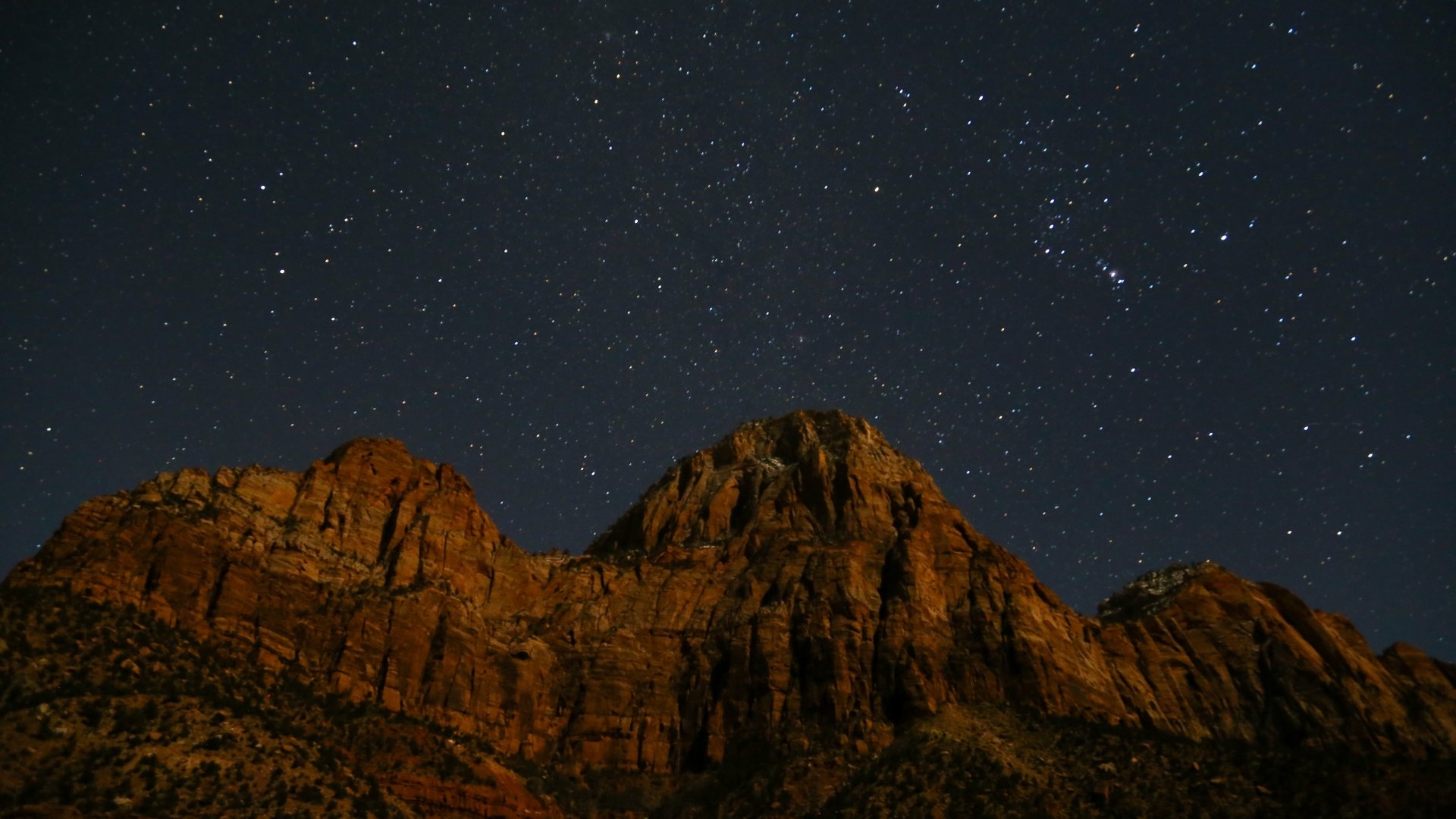4K Ultra HD sci-fi desktop wallpaper featuring rugged mountain peaks under a star-filled night sky, blending natural landscapes with cosmic wonder.