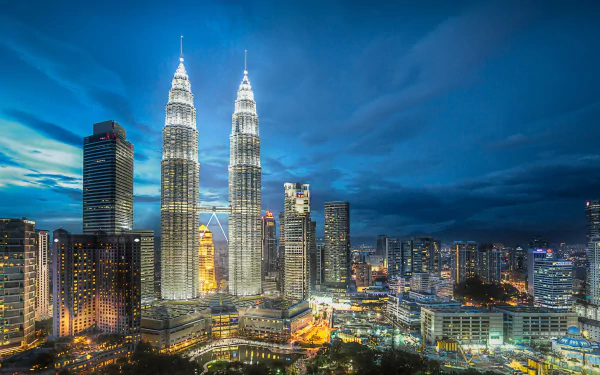 Night view of Kuala Lumpur featuring the illuminated Petronas Towers and surrounding buildings in Malaysia, captured in 4K Ultra HD.