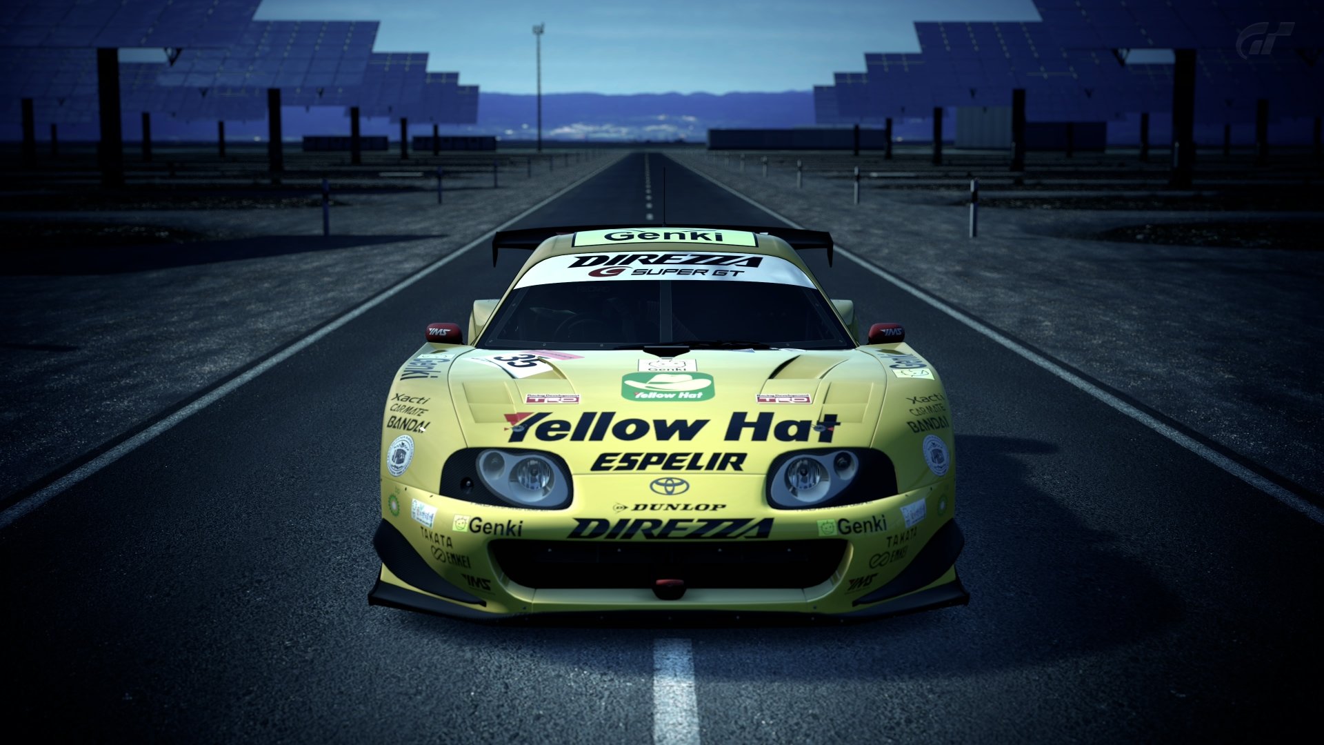 Yellow Toyota Supra race car from Gran Turismo 6 sits centered on a wet racetrack — 4K Ultra HD PC desktop wallpaper and background celebrating the Gran Turismo video game