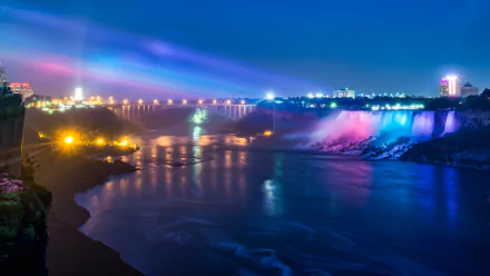 HD desktop wallpaper of Niagara Falls at night showing vibrant colored lights illuminating the cascading water and the surrounding landscape.