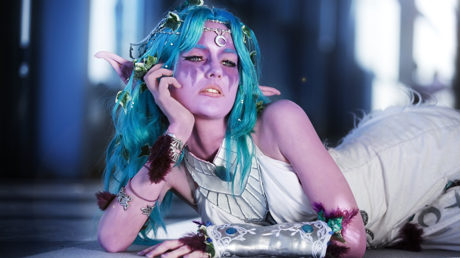 A striking 4K Ultra HD wallpaper featuring a woman in cosplay as Tyrande Whisperwind from World of Warcraft, showcasing vibrant blue hair and intricate details in her costume.