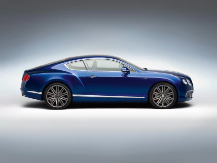 HD desktop wallpaper featuring a sleek blue Bentley Continental GT Speed coupé fastback grand tourer against a gradient background.