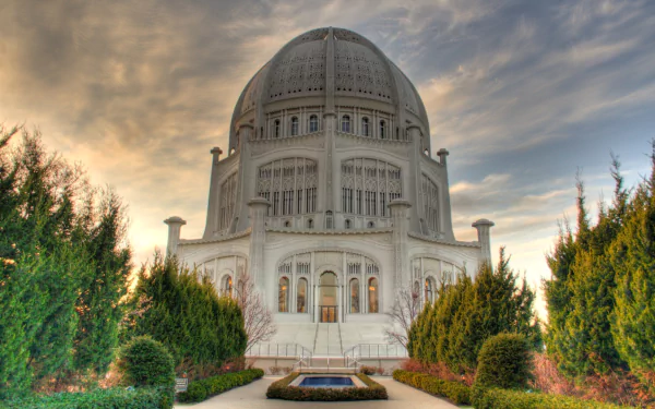 HD desktop wallpaper of the Baha'i Temple, a majestic religious building with a large dome, surrounded by lush greenery under a dramatic sky.