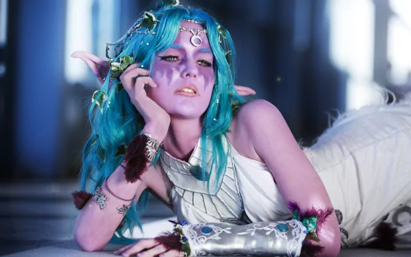 A striking 4K Ultra HD wallpaper featuring a woman in cosplay as Tyrande Whisperwind from World of Warcraft, showcasing vibrant blue hair and intricate details in her costume.