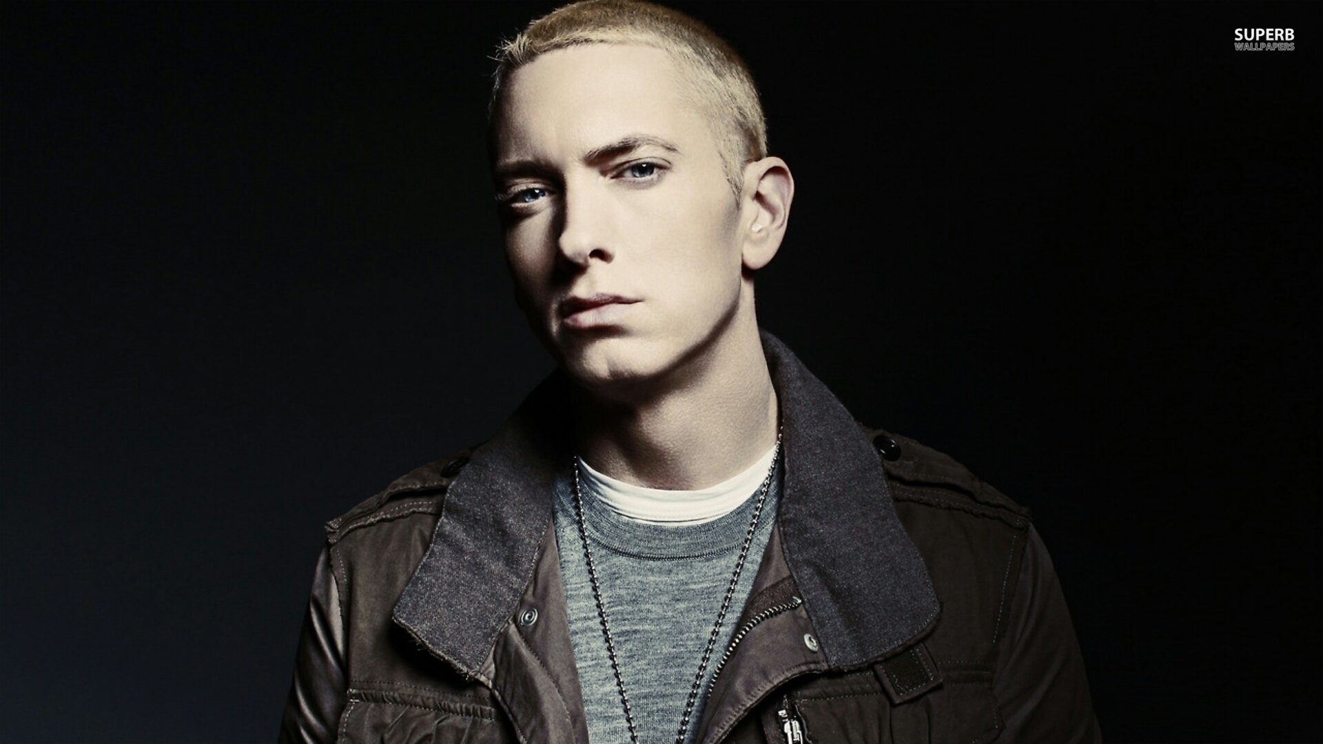 HD PC desktop wallpaper featuring Eminem with a serious expression against a dark background, highlighting the music artist's iconic style.