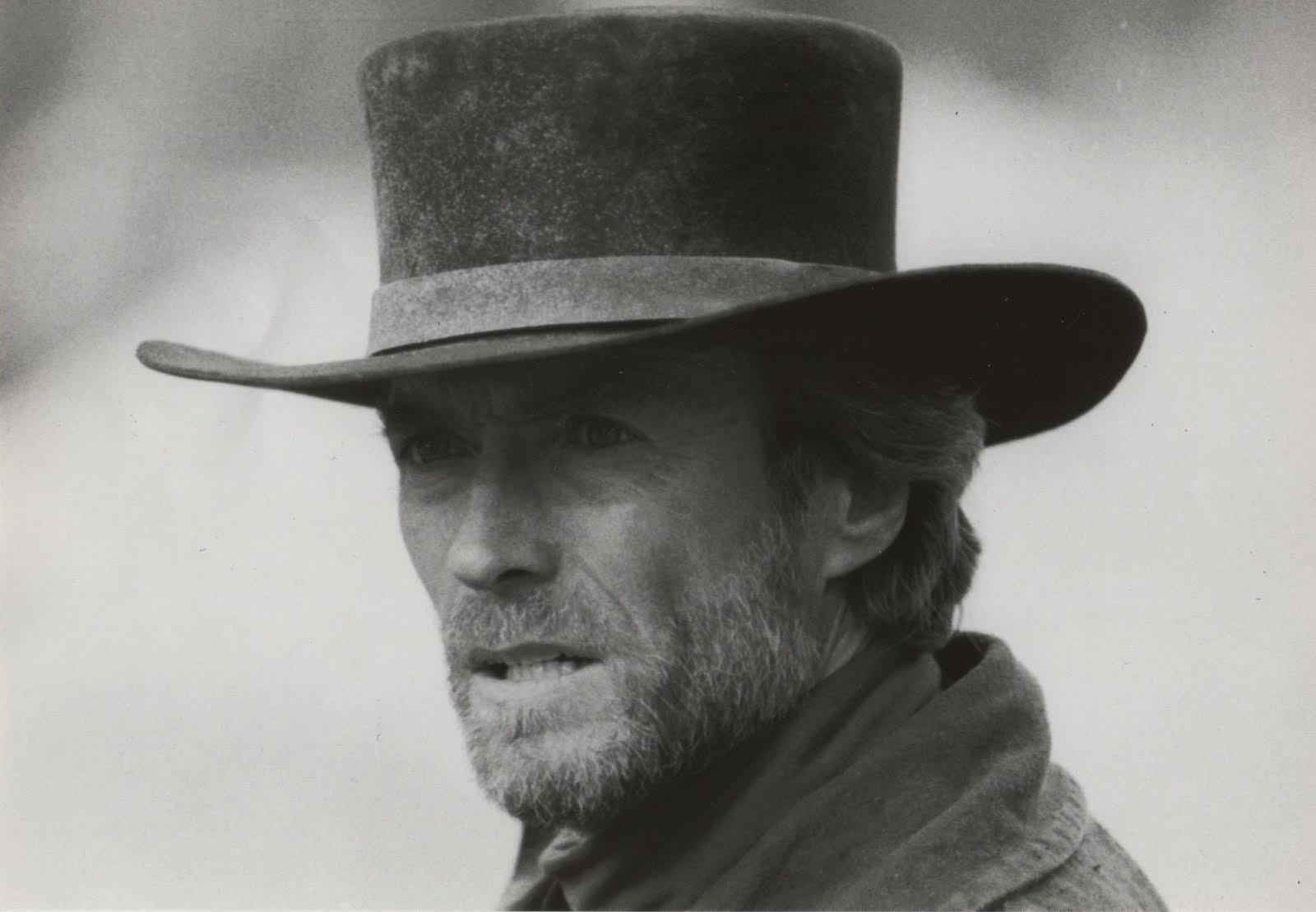Black-and-white HD desktop wallpaper of a rugged male film celebrity in a cowboy hat, close-up portrait evoking classic Westerns.