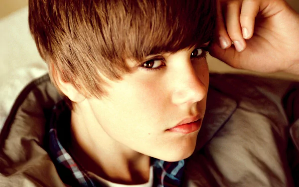 HD desktop wallpaper featuring a close-up of a young man with swept-forward hair and a thoughtful expression.