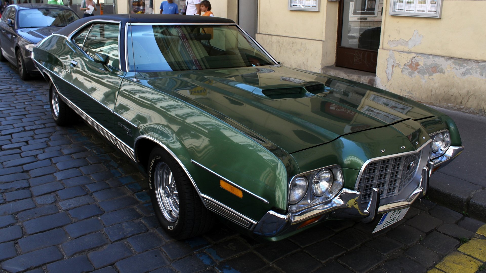 A Ford Gran Torino in vibrant green parked on a city street, showcasing its classic design and chrome accents. Captured in 4K Ultra HD for stunning detail.