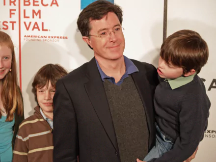 HD desktop wallpaper featuring a smiling man in a suit with three children at a film festival event.