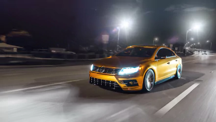 A sleek orange Volkswagen CC speeding on a nighttime highway, captured in stunning 4K Ultra HD as a dynamic PC desktop wallpaper and background.