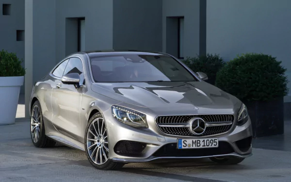 HD desktop wallpaper featuring a sleek silver Mercedes-Benz S-Class Coupe parked in front of a modern building, showcasing luxury and design excellence.