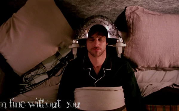 HD wallpaper from Eternal Sunshine of the Spotless Mind featuring Jim Carrey with a memory-erasing headpiece, lying on a bed.