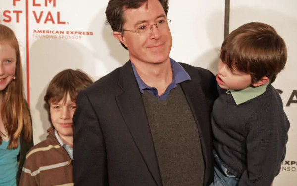 HD desktop wallpaper featuring a smiling man in a suit with three children at a film festival event.