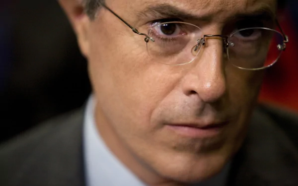 HD desktop wallpaper featuring a close-up of a man wearing glasses, with a serious expression.