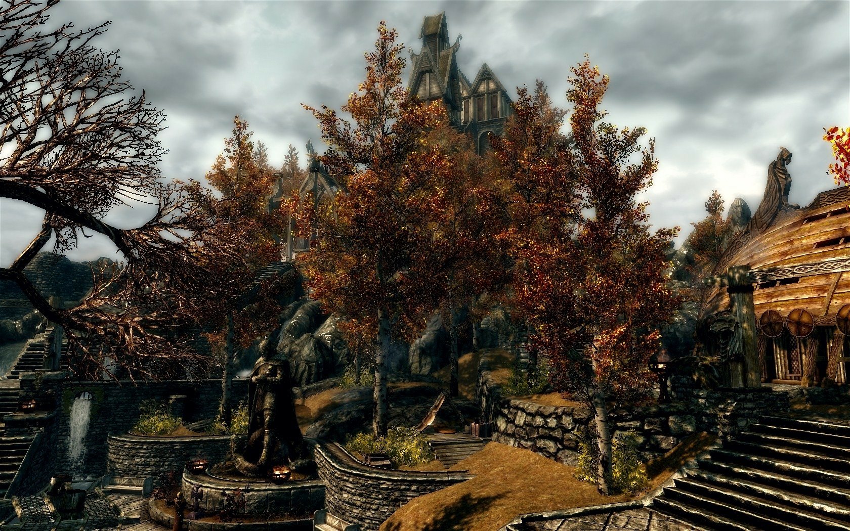 HD PC desktop wallpaper featuring a scenic autumn village scene from the video game The Elder Scrolls V: Skyrim under a cloudy sky.