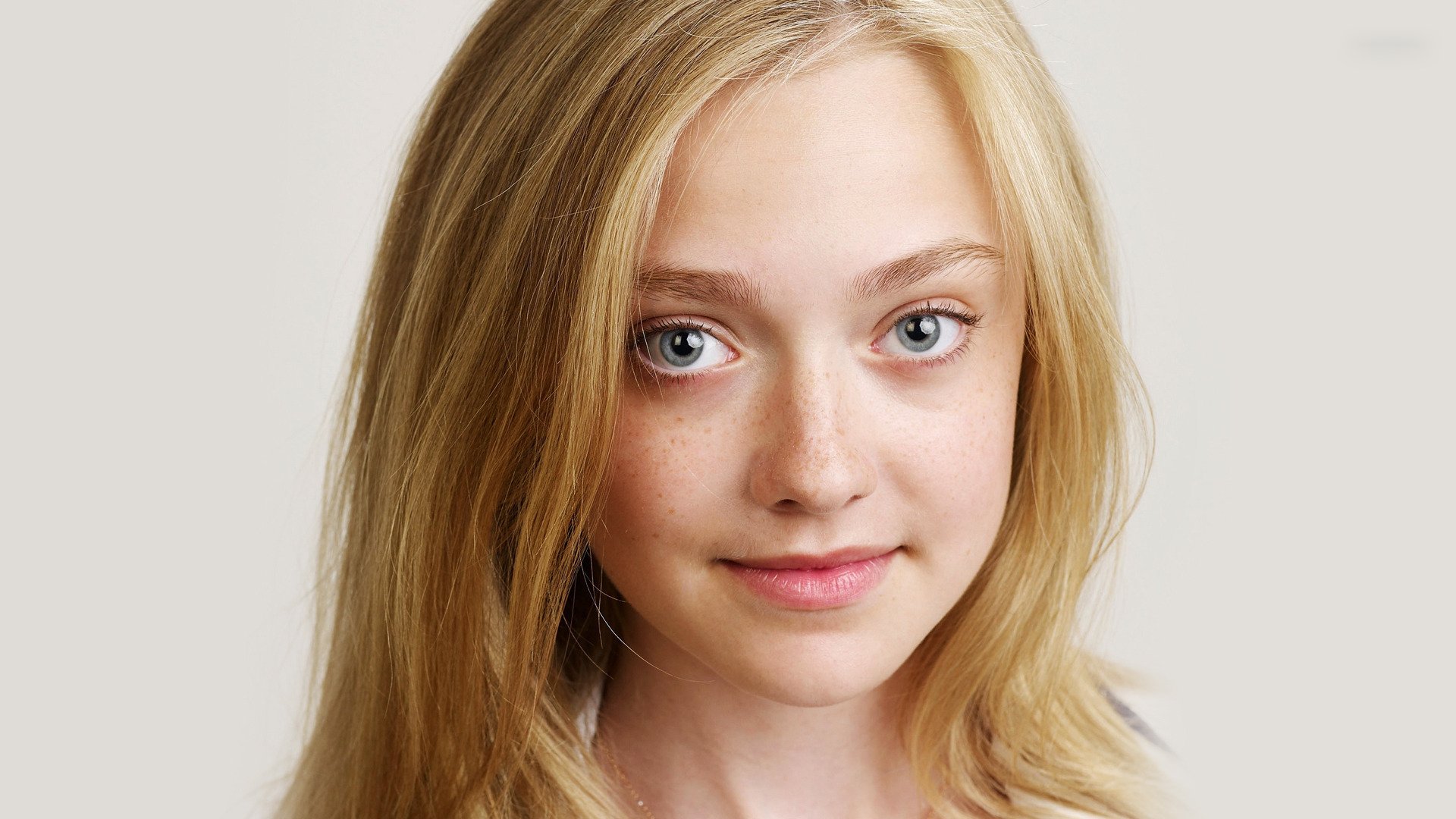 Portrait of American actress Dakota Fanning, featuring her blonde hair and expressive blue eyes, suitable as a high-definition desktop wallpaper or background.