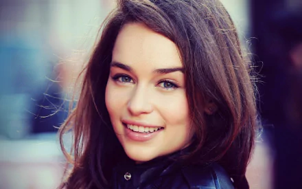 HD desktop wallpaper featuring a close-up of a brunette actress smiling warmly.