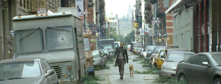 A haunting scene from the movie *I Am Legend*, featuring a lone figure walking a dog through a deserted, overgrown city street, surrounded by abandoned vehicles. HD desktop wallpaper.
