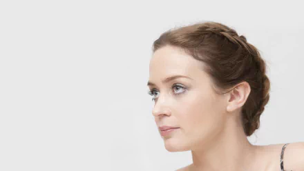 HD PC desktop wallpaper featuring English actress and celebrity Emily Blunt with a serene expression and braided hair against a light background.