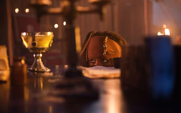Jack Sparrow, played by Johnny Depp in Pirates of the Caribbean: On Stranger Tides, peeks over a table in a dimly lit 4K Ultra HD movie scene.