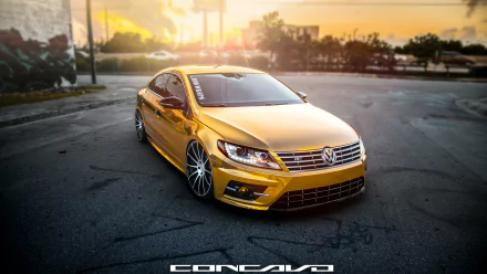 A golden Volkswagen CC parked on an empty street at sunset, featured as a 4K Ultra HD desktop wallpaper with sharp details and vibrant lighting.