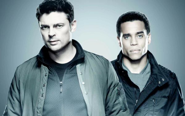 HD desktop wallpaper featuring two actors from the show Almost Human, set against a blue-toned background.