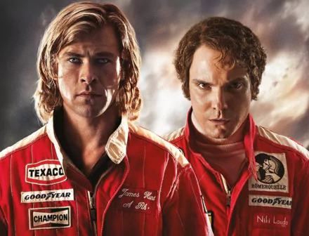 HD wallpaper from Rush (2013) featuring two racecar drivers in red racing suits, with intent expressions.