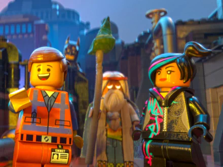HD PC desktop wallpaper featuring LEGO Batman, Wyldstyle, Vitruvius, and Emmet from The LEGO Movie in a vibrant city scene.