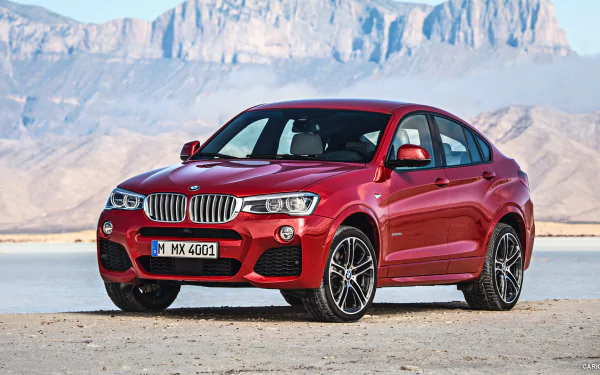 Red BMW X4 on a salt flat with distant mountains, HD PC desktop wallpaper and background.