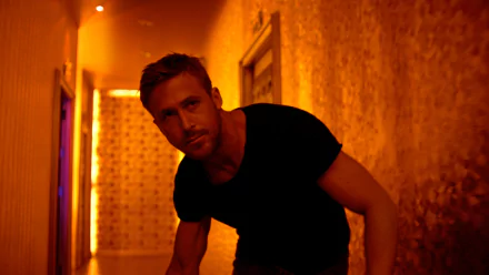 HD desktop wallpaper featuring Ryan Gosling in a dimly lit orange hallway from the movie Only God Forgives.