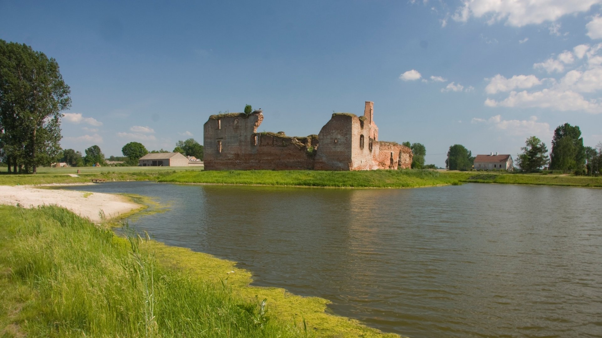 HD desktop wallpaper showcasing the historic man-made Besiekiery Castle surrounded by water under a bright blue sky.