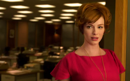 HD desktop wallpaper featuring American actress and celebrity Christina Hendricks in a red dress against an office background.