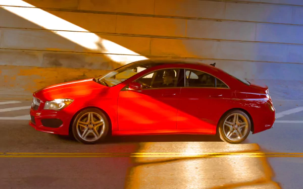 HD PC desktop wallpaper featuring a red Mercedes-Benz CLA-Class parked indoors with warm sunlight casting dramatic shadows on the vehicle and surrounding walls.