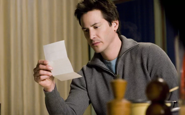 Actor from the movie The Lake House reads a letter at a table; moody 2K Quad HD PC desktop wallpaper/background.