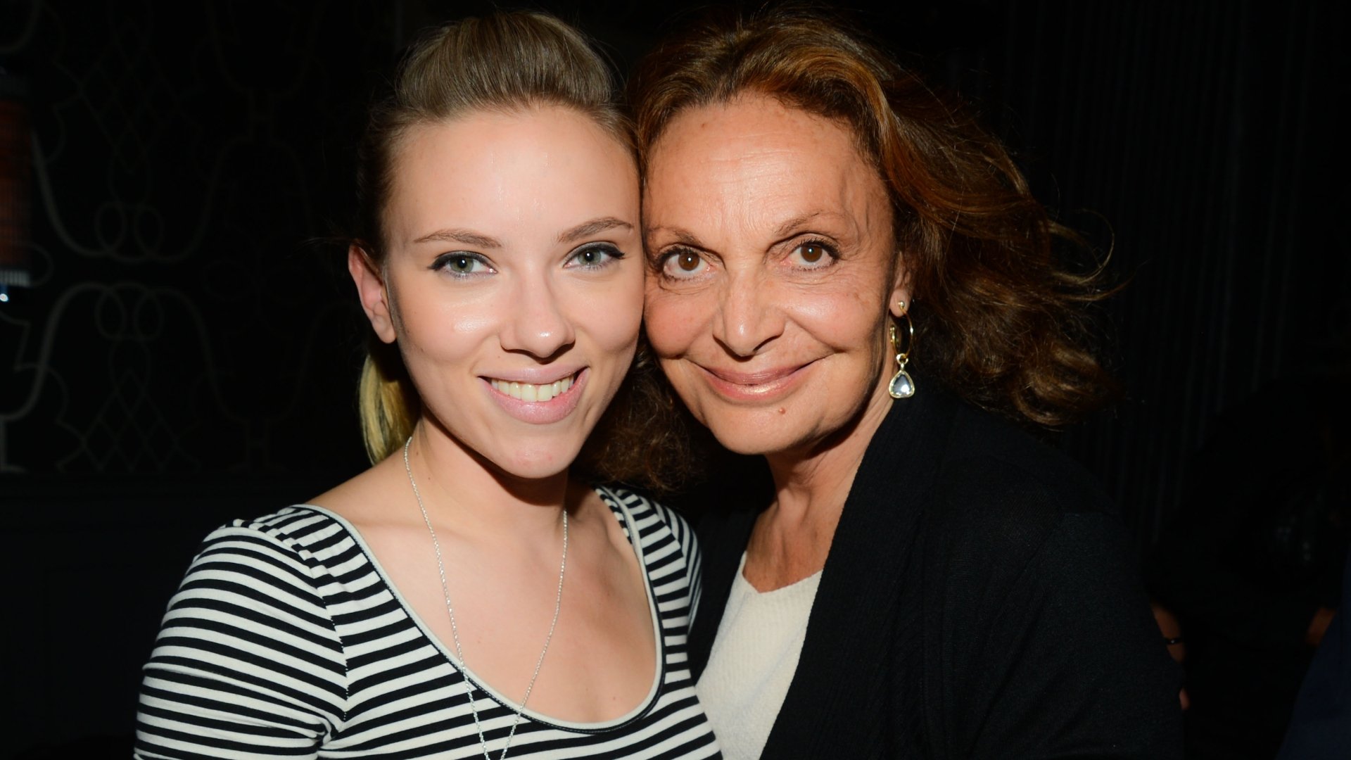 HD PC desktop wallpaper featuring a close-up of Scarlett Johansson and another woman smiling together against a dark background.