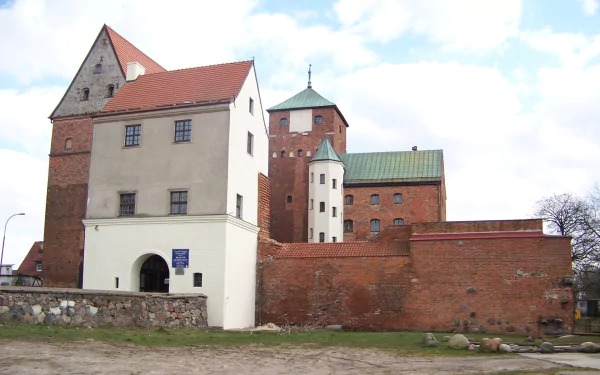 HD PC desktop wallpaper of the man-made Castle of Pomeranian Dukes: red-brick towers and a white manor set against a bright blue sky.