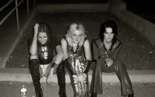 HD desktop wallpaper featuring Kristen Stewart and Dakota Fanning from the movie The Runaways, sitting on outdoor steps in black and white.
