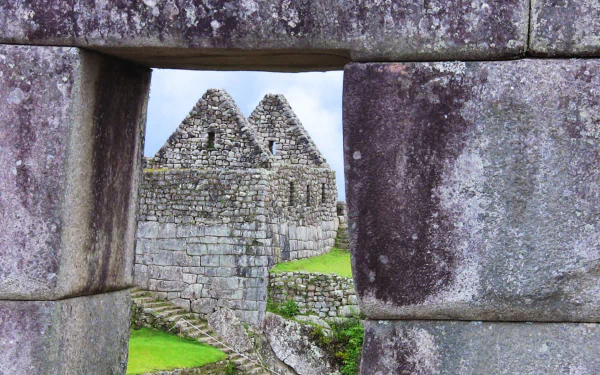 HD PC desktop wallpaper featuring the man-made stone structures of Machu Picchu framed through an ancient stone window.